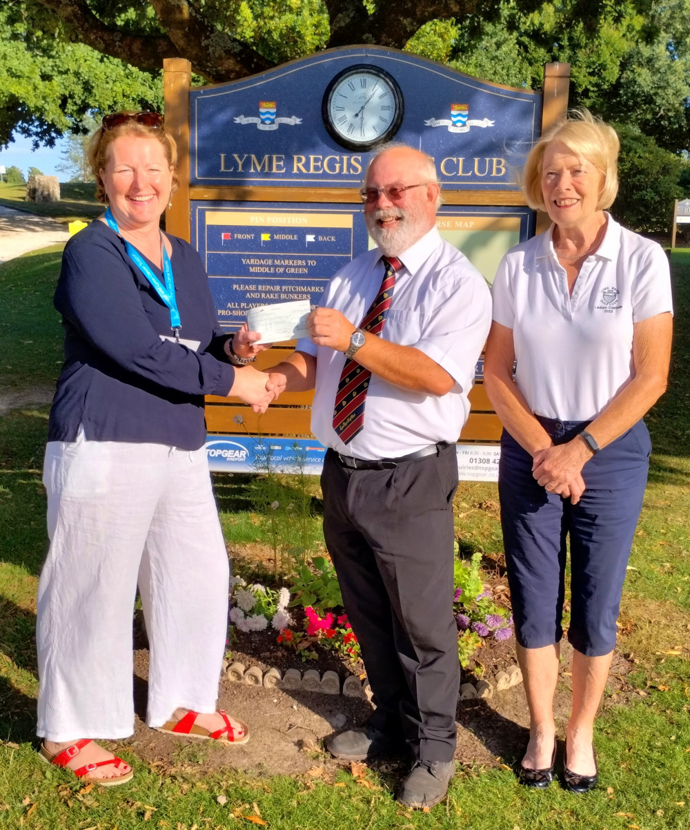 Lyme Regis Golf Club captains Steve Hames and Mary Minter present a cheque to Mary Kahn, founder of Axminster and Lyme Cancer Support