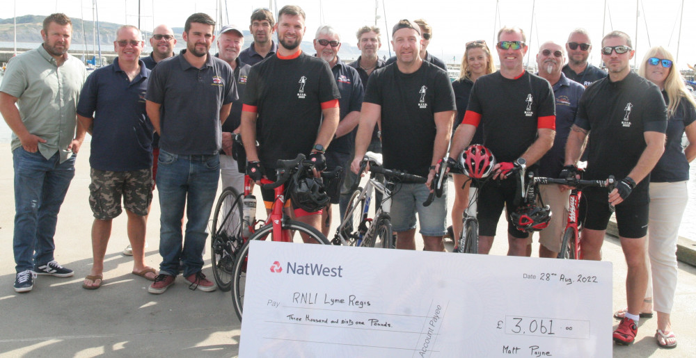 Cycliusts Matthew Payne, Rob Gage, Andrew ‘Edder’ Gage and Dan Galloway present a cheque to members of Lyme Regis lifeboat crew