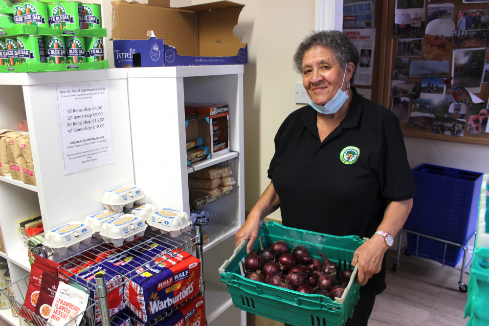 Kathleen Wilshaw with some red onions, one of the shop's many fresh fruit and vegetable offerings. (Image - Alexander Greensmith / Congleton Nub News)