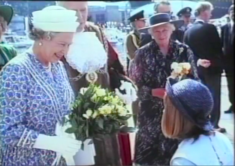 Her Majesty accepting a white posey of roses from a young girl during her visit to Kingston in 1992 (Credit: Screengrab, Kingston Heritage Service).