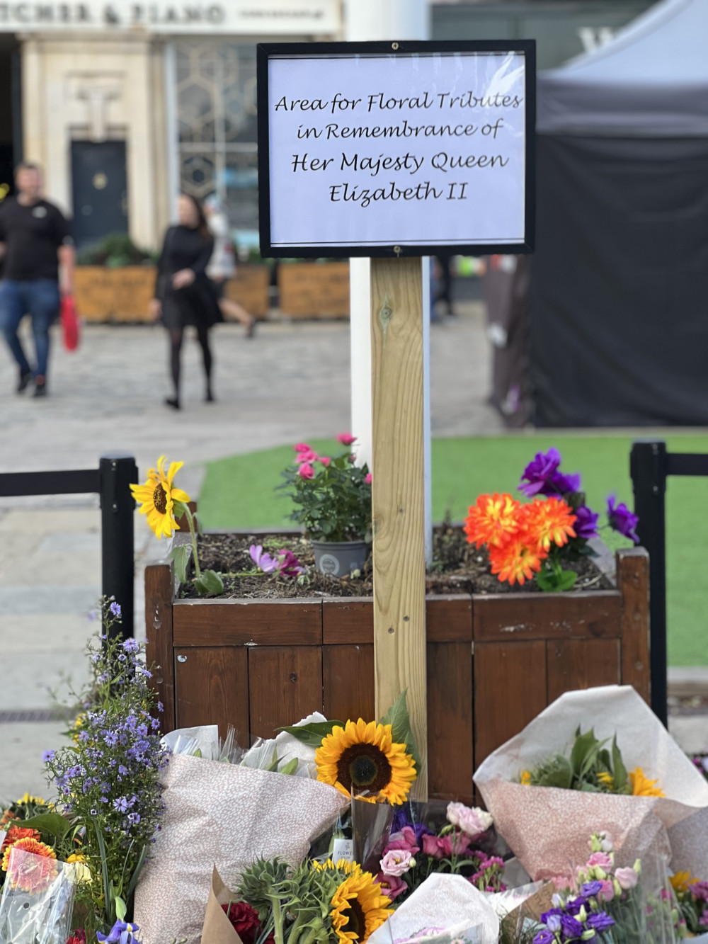 The sign next to the flagpole in Hitchin Market Place reads: 'Area for floral tributes in Remembrance of Her Majesty Queen Elizabeth II." PICTURE CREDIT: @HitchinNubNews 