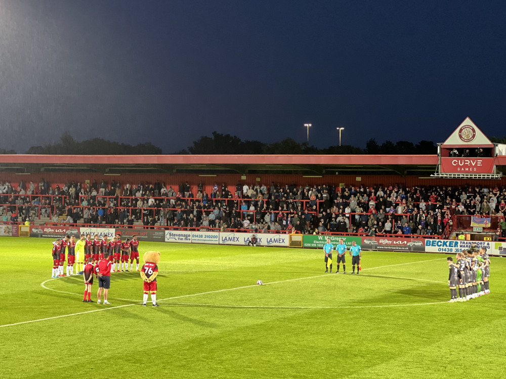 Stevenage and Newport County teams take part in a minute's silence to honour Her Majesty, Queen Elizabeth II. CREDIT: @laythy29  