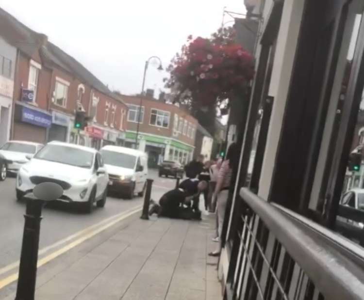 A woman is held to the ground by police outside Wetherspoons