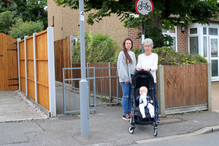 One of Malvern Road’s longest-standing residents, Janice Haley (right), with her daughter Emma, and grandson Teddy – one of the street’s newest residents – at the entrance to the footpath which they say could become an accident hotspot if the Thornhill Road bus lane gets the greenlight. 