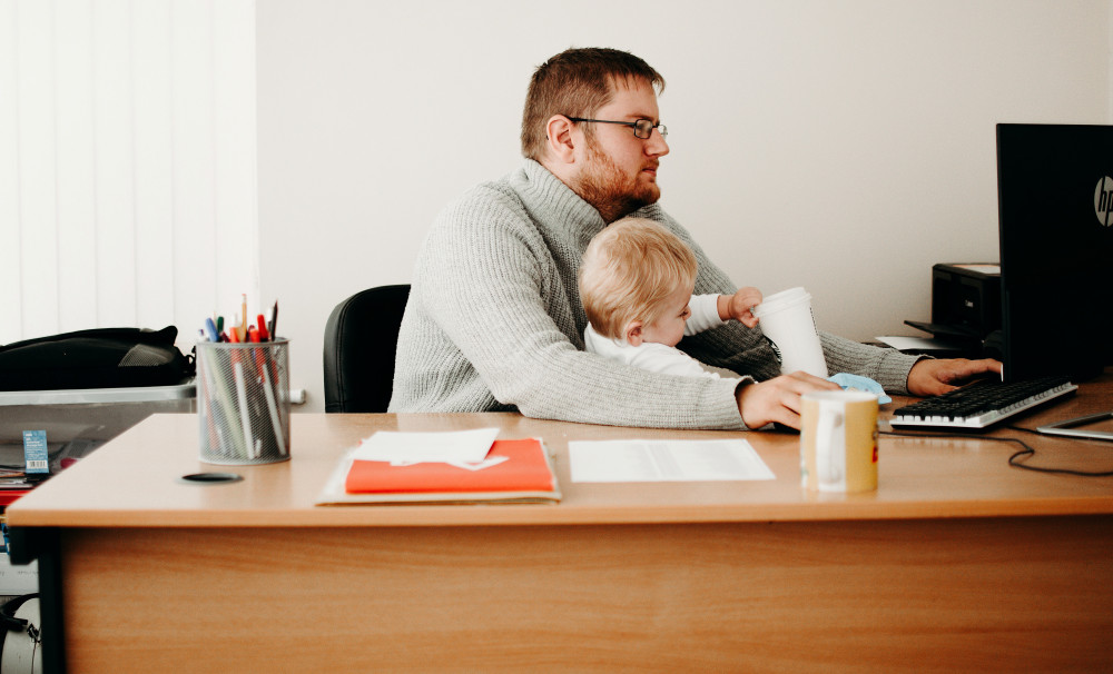 Man working from home with child (https://www.pexels.com)