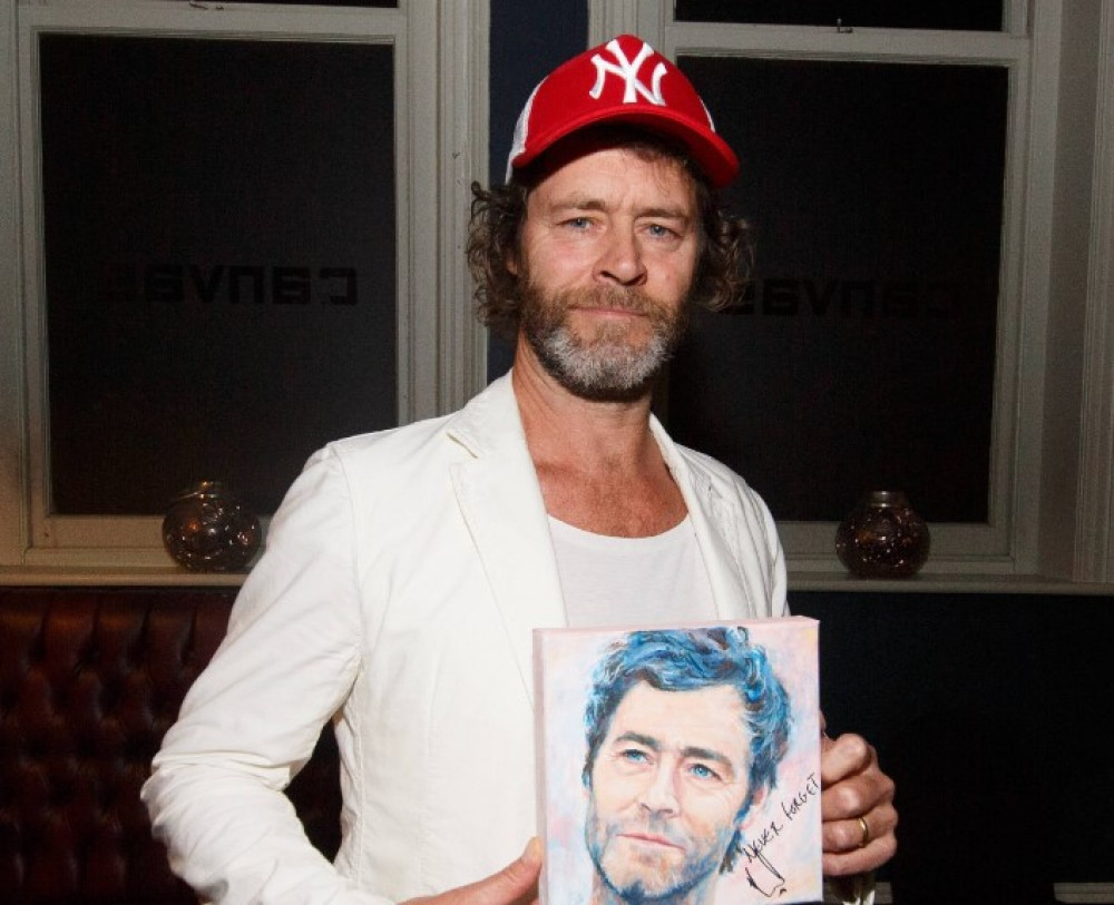 Take That singer Howard Donald with his portrait signed for charity. Credit: Paul Thompson at Oak Photography.