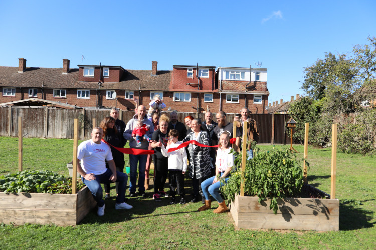 Local residents cut the red ribbon to celebrate the official launch of Clayburn Community Garden.