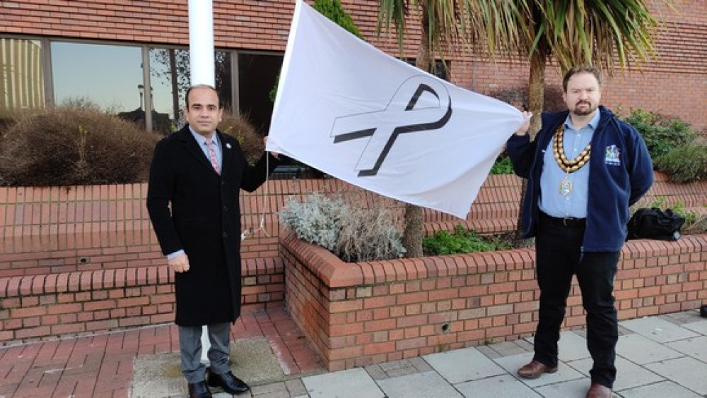 Cllr James Halden and Cllr Qaisar Abbas raise the flag.