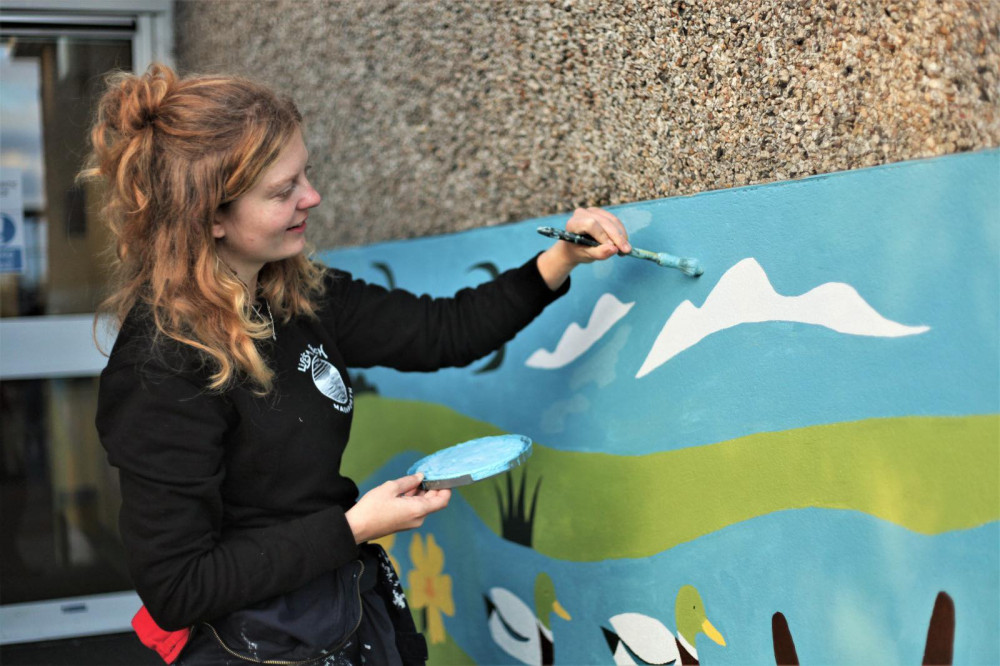 Holly Astle paints the mural at Mylor Bridge Community Primary School 