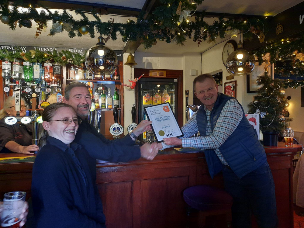 The team accepting the award from CAMRA representative Rich Harris.