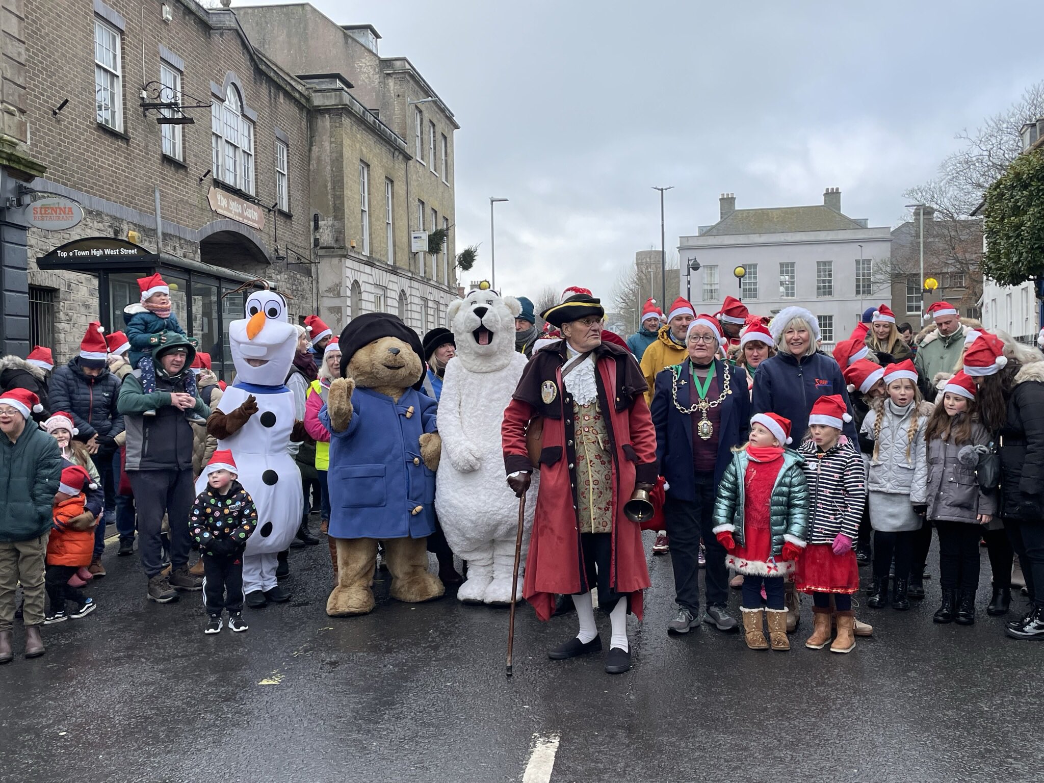 Town crier Alistair Chisholm; the Mayor of Dorchester, Cllr Janet Hewitt; and favourite children's characters lead the Santa hat parade (photos courtesy of Steve Bulley)