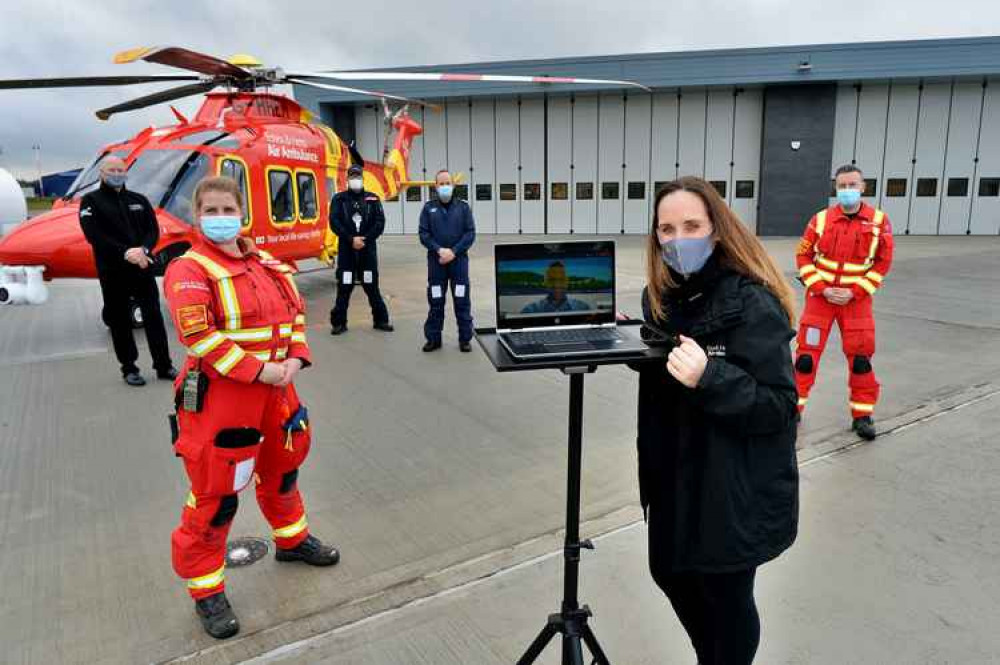 Mark Hart hands over the new base virtually to Jane Gurney accompanied by (L-R) Cliff Gale, Gaynor Wareham (Critical Care Paramedic), Lee Burling (Pilot), Clive Sturdy (Co Pilot) and Ben Clarke (Pre-hospital Care Doctor). The aircraft is the charity's A