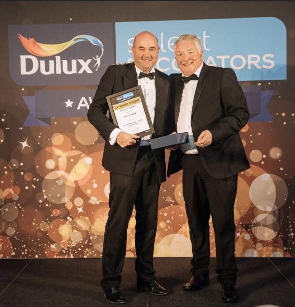 Nick Dodge (left) collects the award for exterior project on behalf of Actionline Decorating at the Dulux Select Decorator Awards