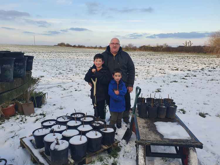 A project in all weathers: Andy Carr with sons Alex and Aaron planting trees