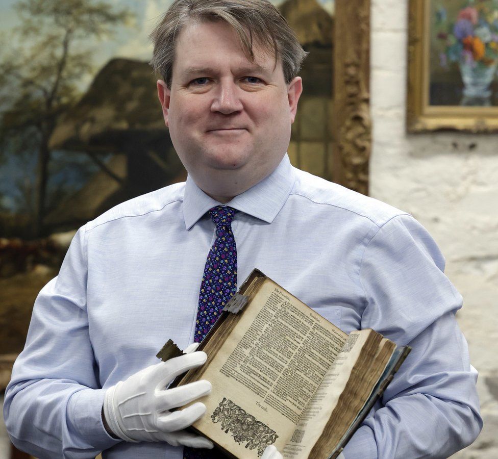 Bloomfield Auctions managing director Karl Bennett with the Geneva Bible (photo credit: Bloomfield Auctions)