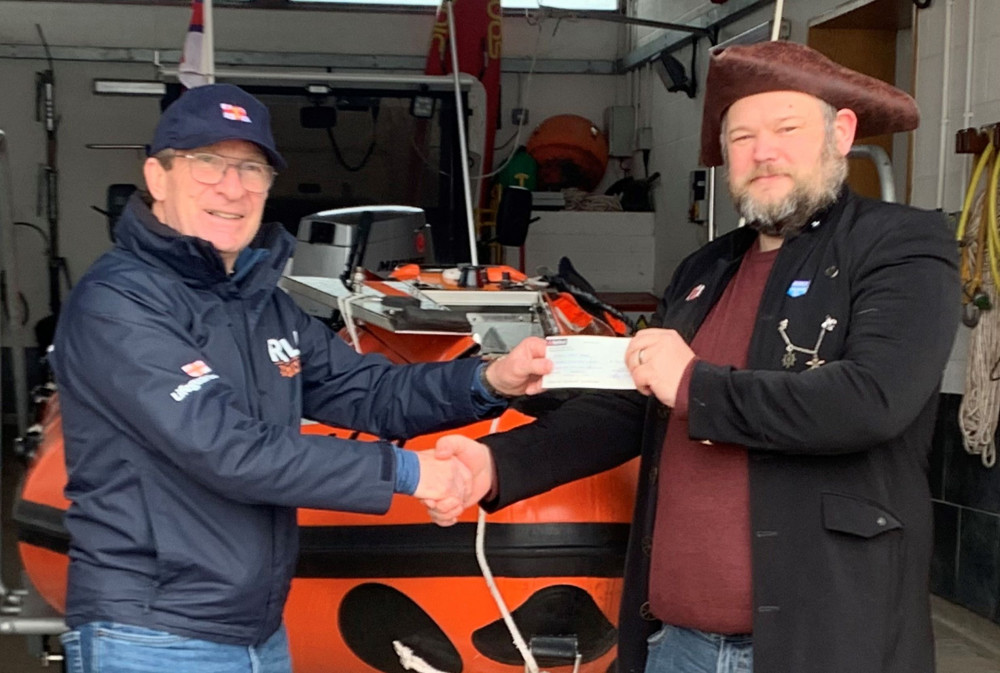 Daniel Versen-Phillips (R) presents the cheque to Chair of Exmouth RNLI Fundraising Team, Des White (L).