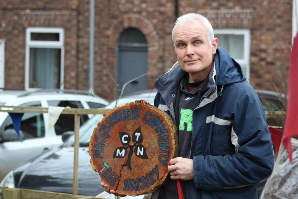 Paul with a logo for Macclesfield Community Tree Nursery - naturally - made out of wood. (Image - Alexander Greensmith / Macclesfield Nub News)