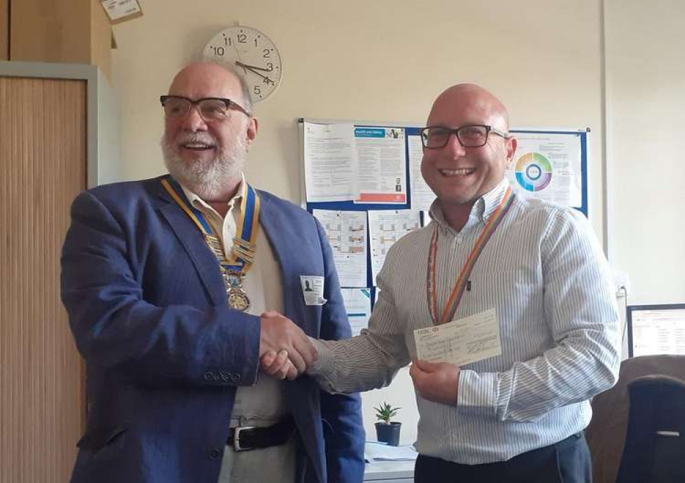 Councillor Edwards (left) presenting the cheque to Jonathan Sly (right)