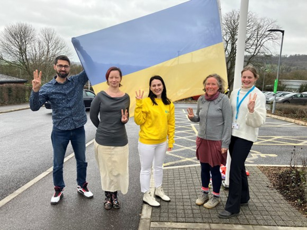 The Homes for Ukraine team standing outside Blackdown House, where the Ukranian flag is flying