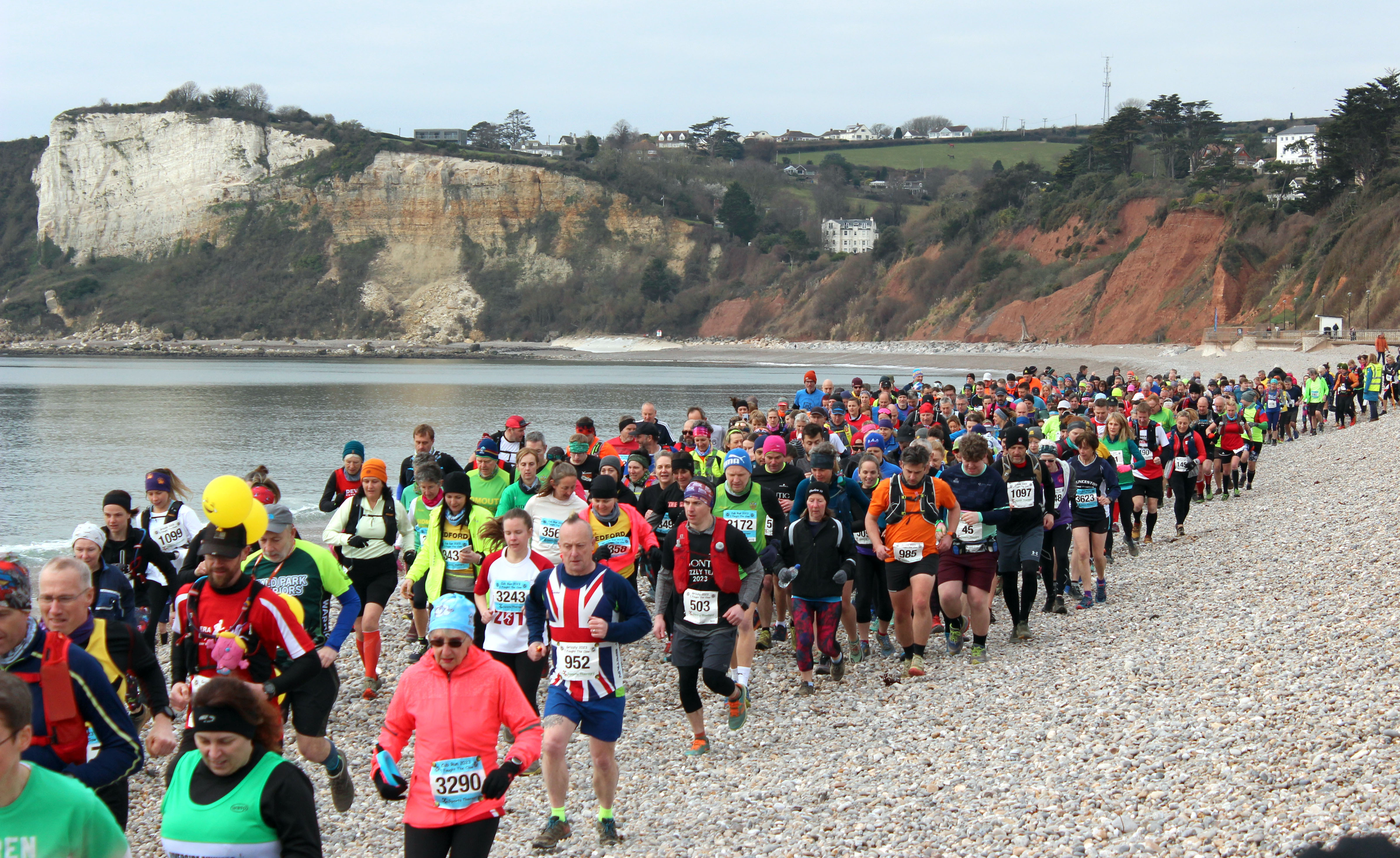 Runners make their way along the pebble beach at the start of the race