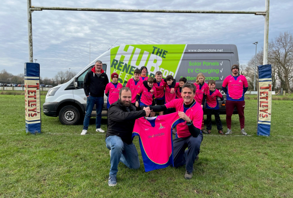 Samm Patey, branch manager at Devondale’s Glastonbury branch, with Ian Armstrong from Tor Rugy Club’s U13 team, and the players in their new shirts.  