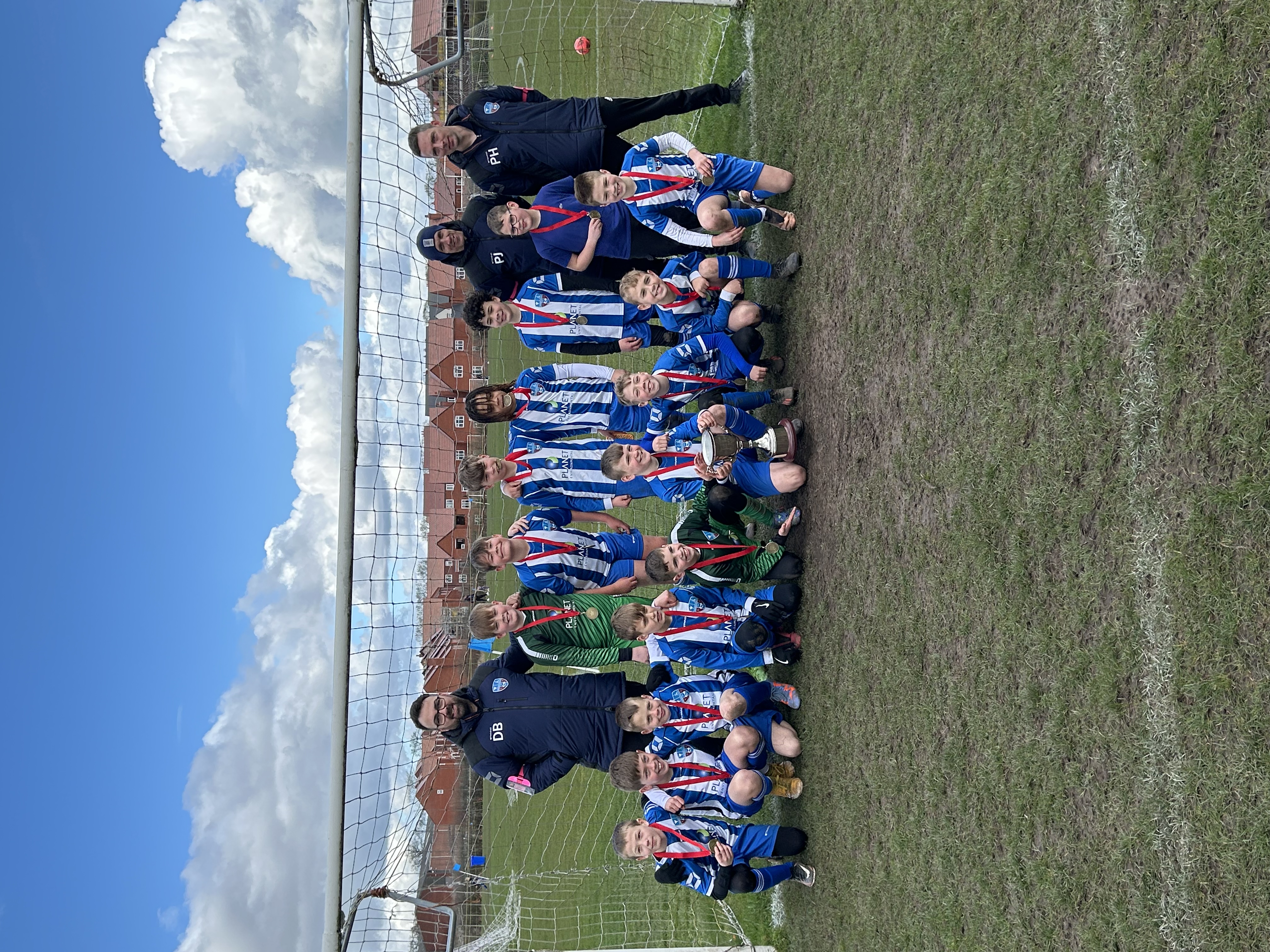 The team celebrate with the coveted trophy.