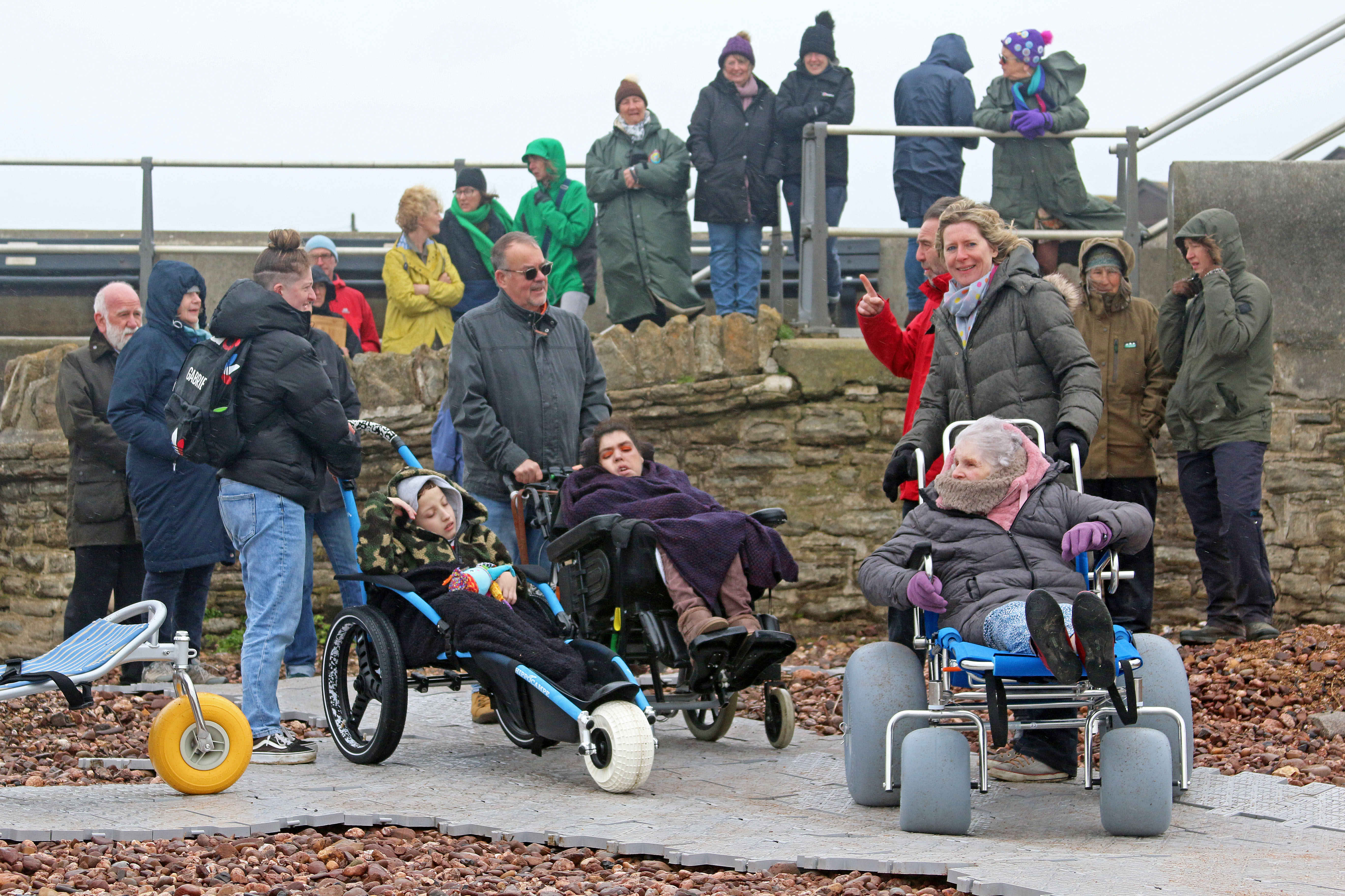 Residents try out the new West Bay beach wheelchairs at the launch event on Friday (photo credit: Garry Hayball)