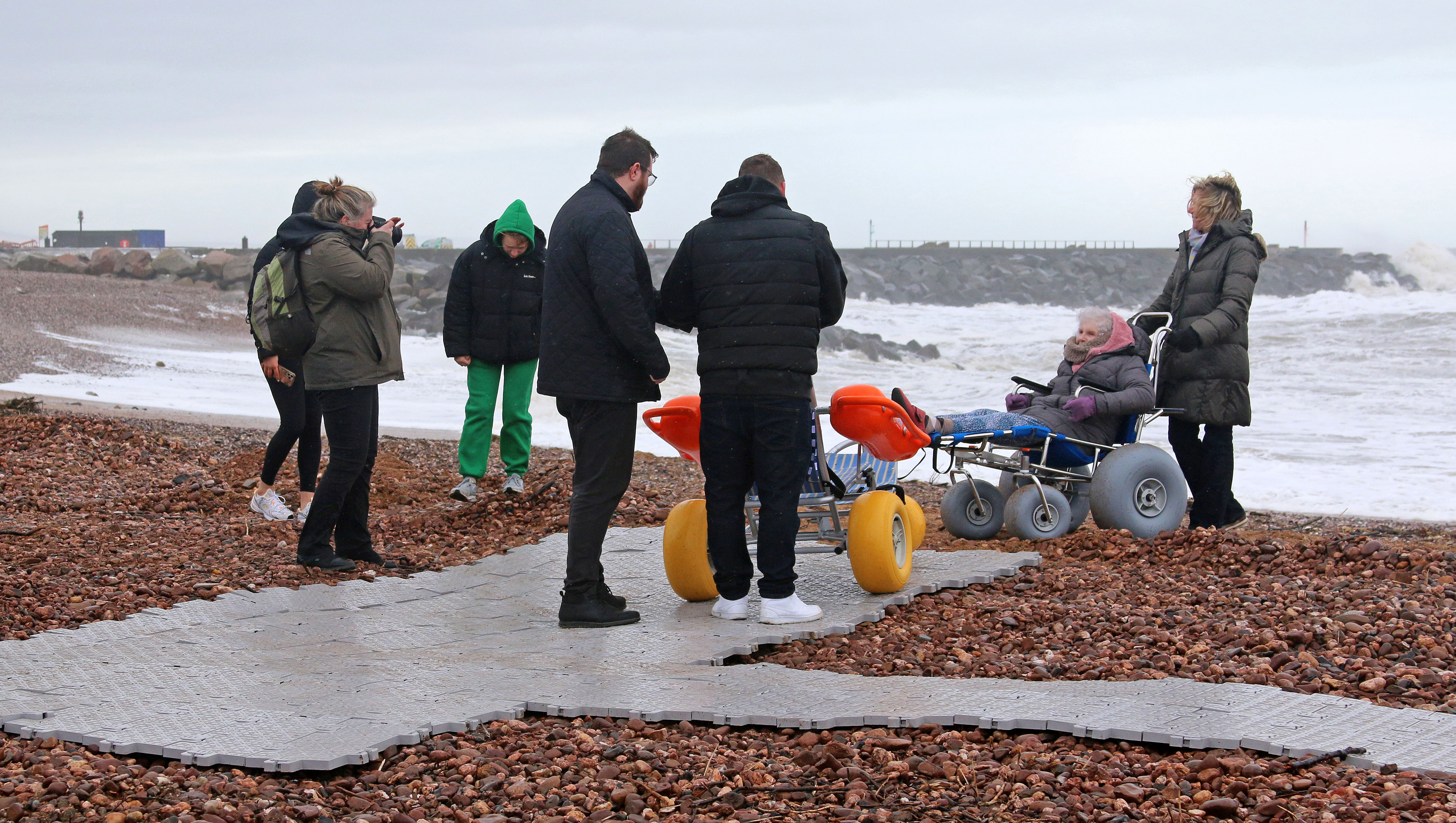 Residents try out the new West Bay beach wheelchairs at the launch event on Friday (photo credit: Garry Hayball)