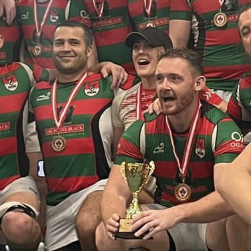 Lee celebrates with his team and captain with the cup. 