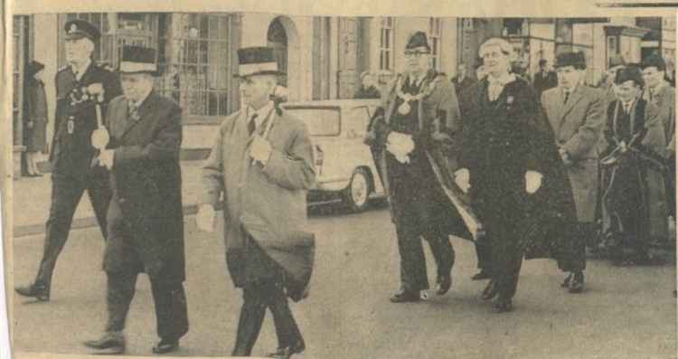 In 1965: The Mayor of Cowbridge walks in procession from the Church of the Holy Cross, to the Town Hall following the Remembrance Day Service . He is accompanied by the Town Clerk Mr J Thornley Taylor, and the Chairman of the Cowbridge RD. Council (Coun.