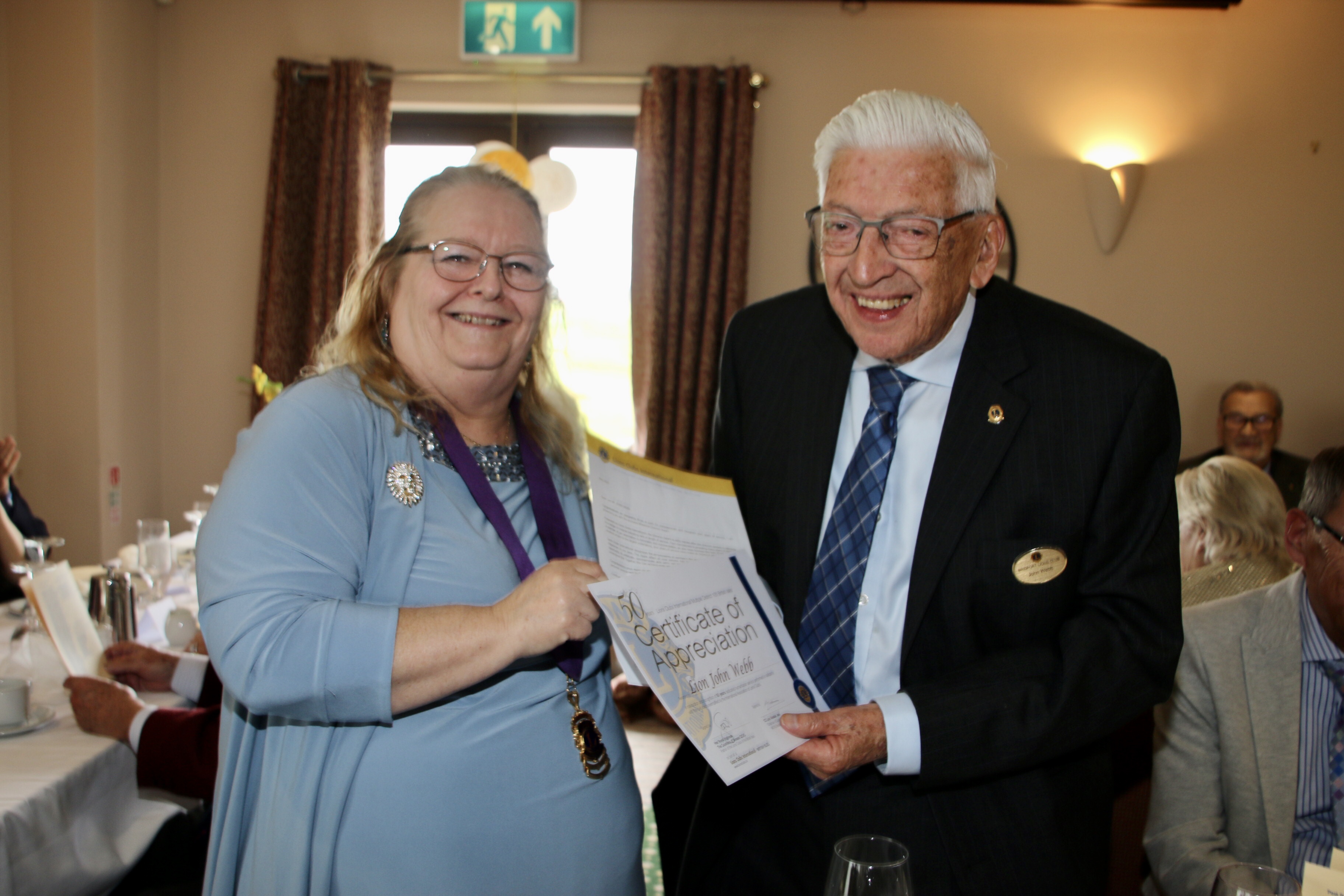 Lion John Webb receives his 50 year certificate from district governor Lesley Chudley