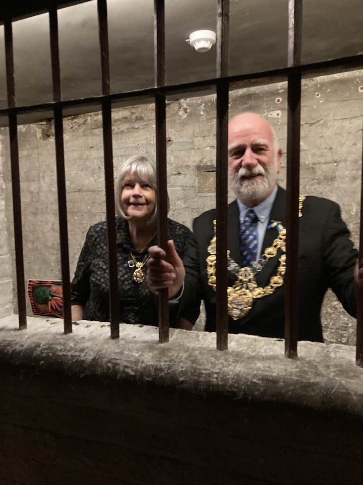 The Mayor of Bridport, Cllr Ian Bark, and mayoress Anne Bark, behind bars at Shire Hall Museum (photo credit: Discover Dorchester/Dorchester Town Council)