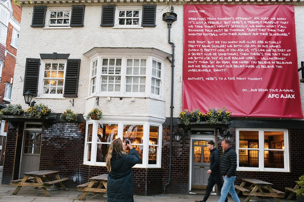 Under the cover of darkness, a small ‘hit squad’ from the Dutch football club AFC AJAX slipped into Richmond and switched the Ted Lasso pub sign at The Prince’s Head back to The Crown & Anchor