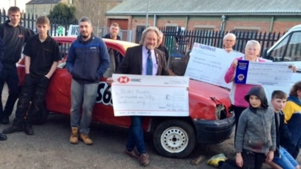 Members of the Bridport Bandits receive cheques from local community organisations