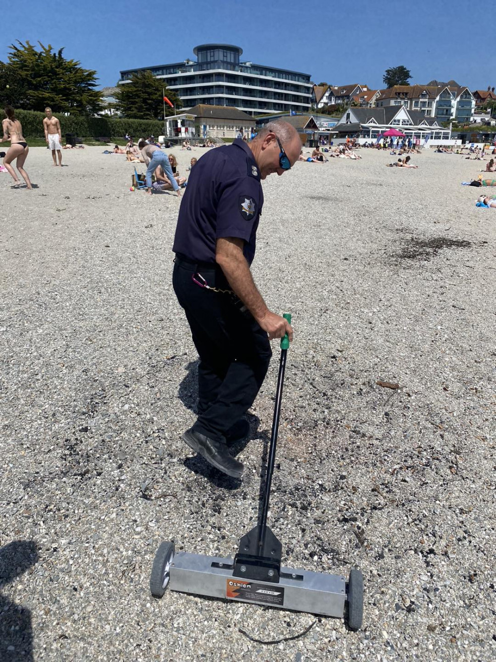 A member of the team using the magnetic rake on Gylly Beach (Image: Falmouth Community Fire Station) 