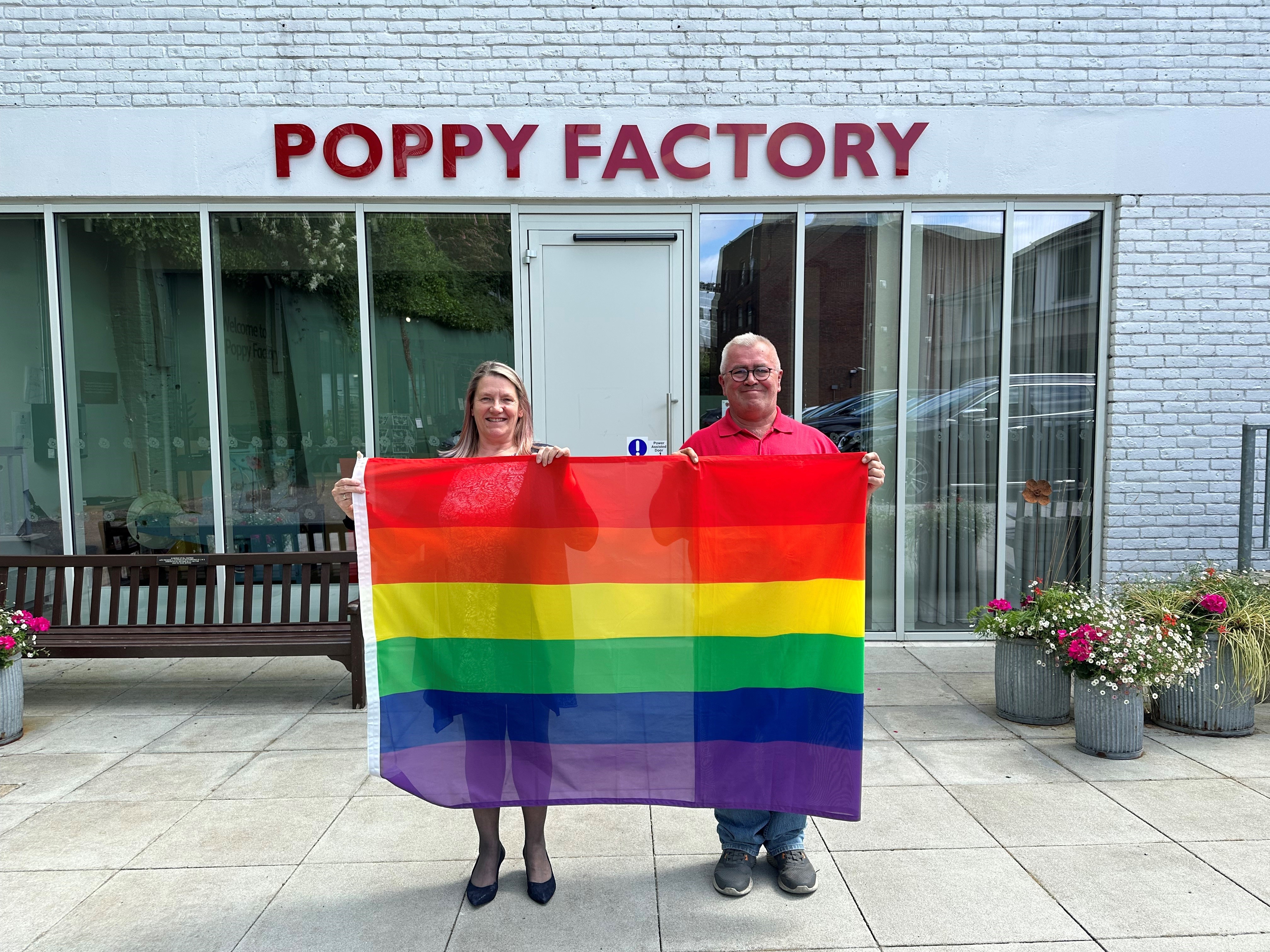 Debbie Boughtflower, Director of Operations, and Steve Pleasants, Production Operative at The Poppy Factory, ready to raise the rainbow flag