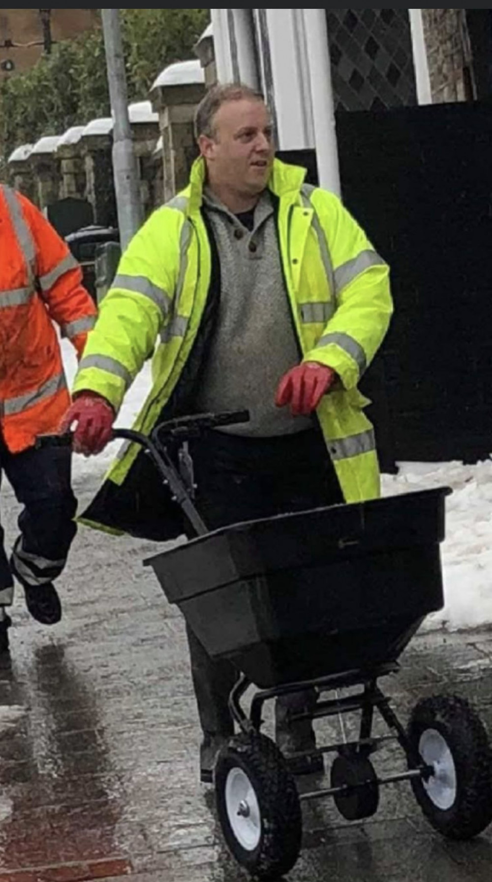 Cllr Baker helping to grit pavements after winter snowfall