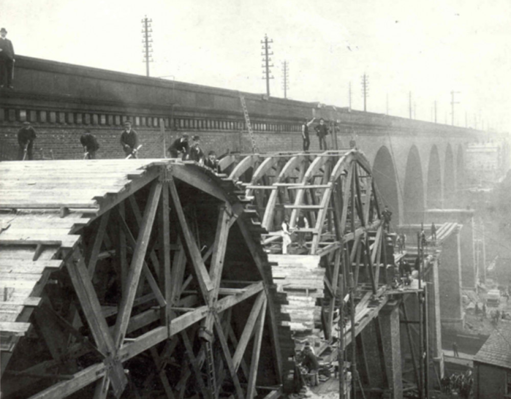 Working on the second viaduct, shows men on the top of the wooden centres for forming the arches (Image - Stockport Heritage Trust)
