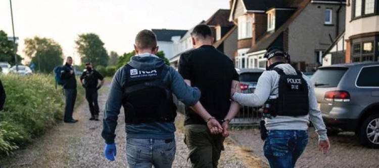 The man is arrested in Grays. Picture by Press Association who accompanied officers on the raid. 