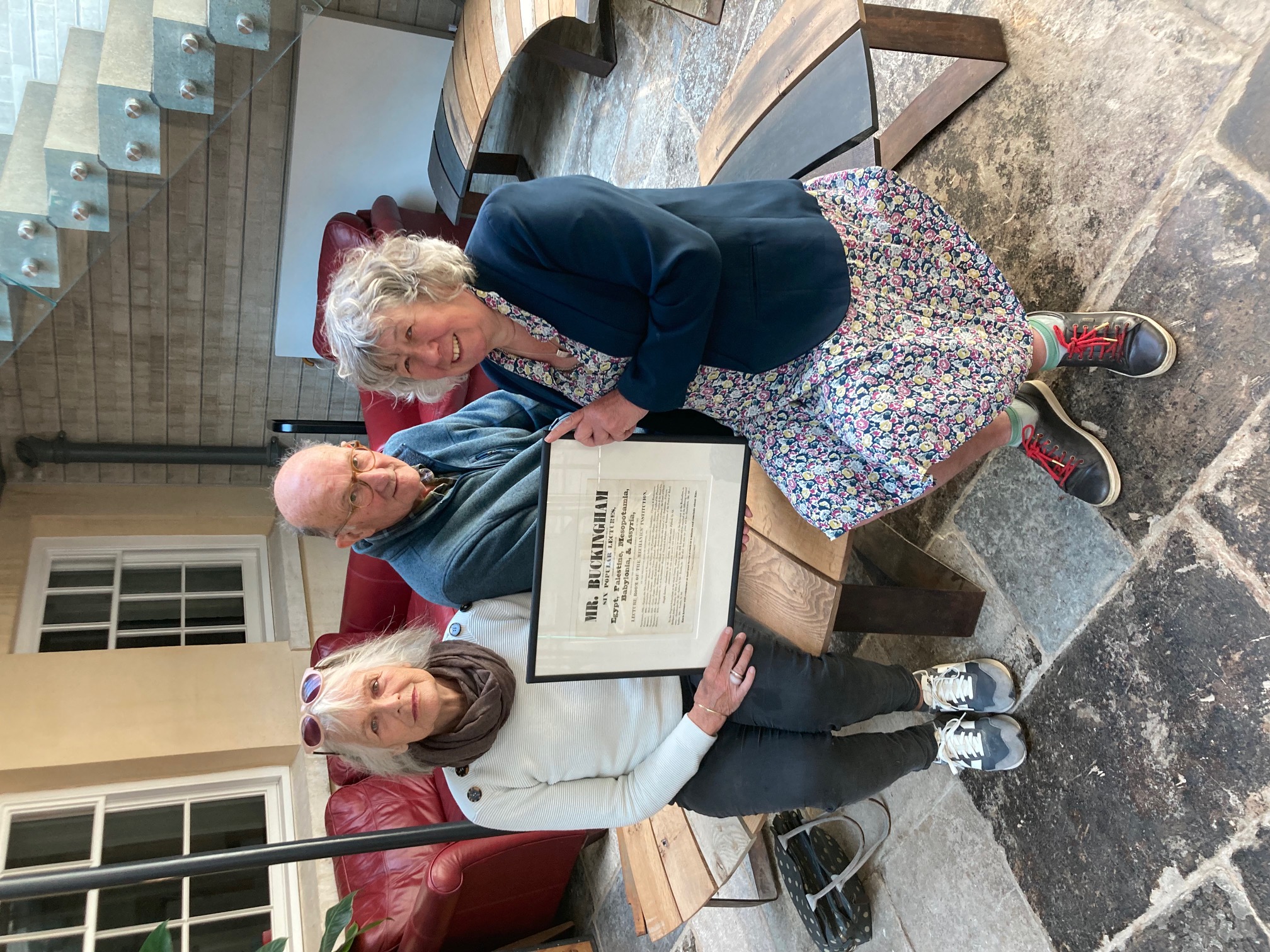 Rosie Young (left)  co-owner of Bridport Old Books, architectural historian Tim Connor, and Phyllida Culpin, chair of Bridport Area Development Trust, unveil the poster in the courtyard at the LSi