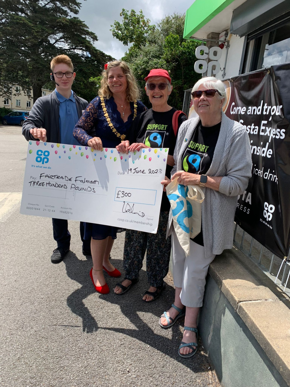 Mayor Kirstie Edwards and Co-op Customer Team Member Harry Dymock present the cheque to Pat Fitzpatrick and Mary Bradley of Fairtrade Falmouth 