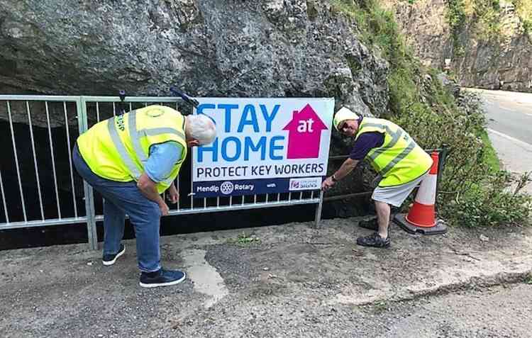 Mendip Rotarians fixing Covid-19 warning signs in Cheddar