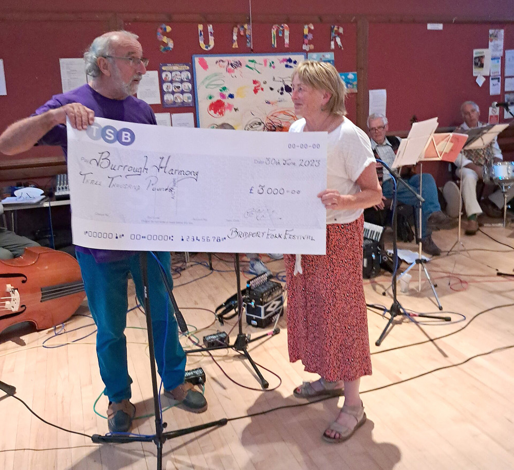 Chris Deacon of Bridport Folk Festival presents a cheque for £3,000 to Ali Cliffe of mental health charity Harmony