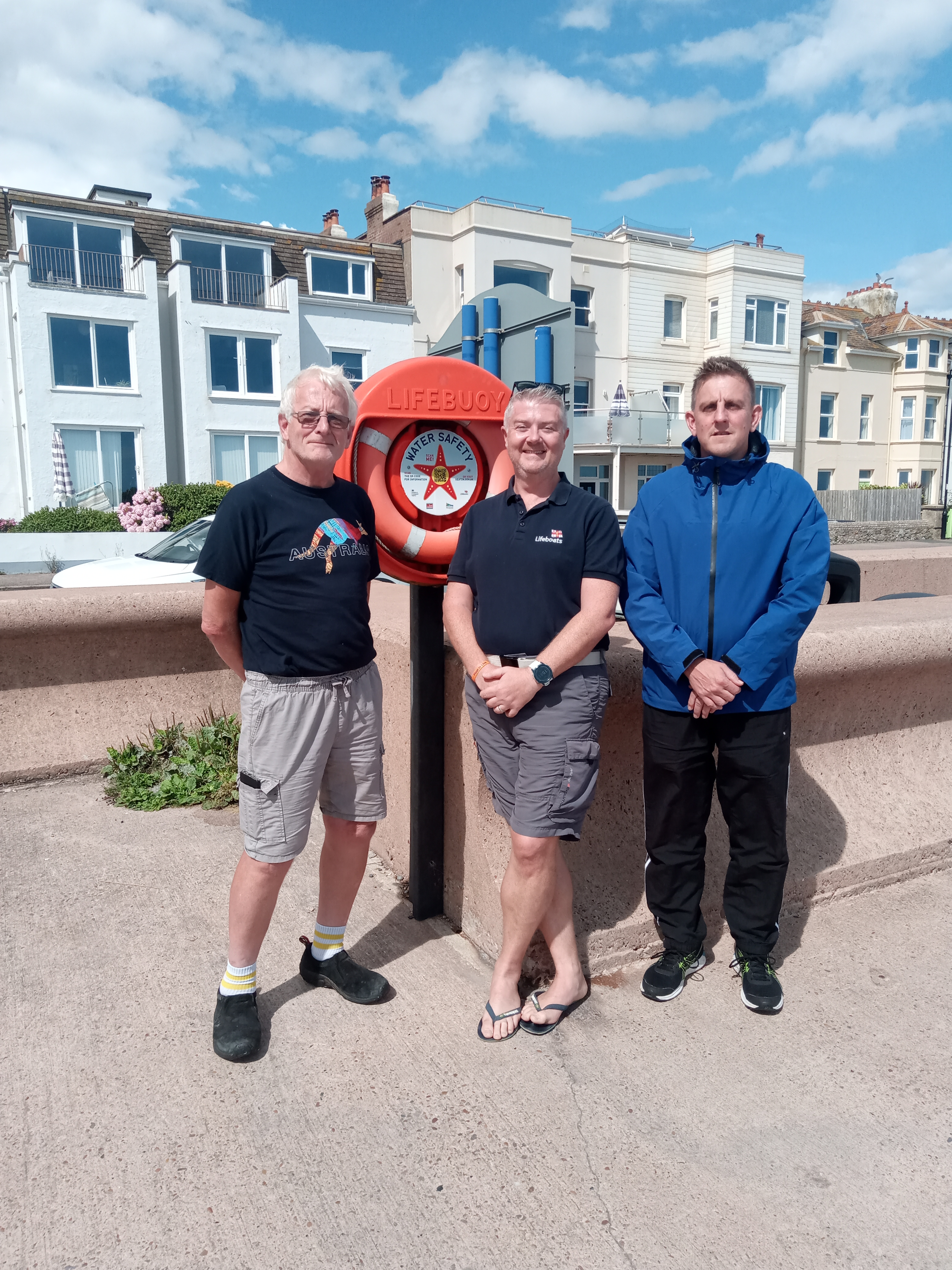 Seaton town councillor Peter Burrows RNLI water safety advisor Steve Shaw, and Seaton Town Council's facilities and projects officer Paul Johns with the life ring with starfish QR code