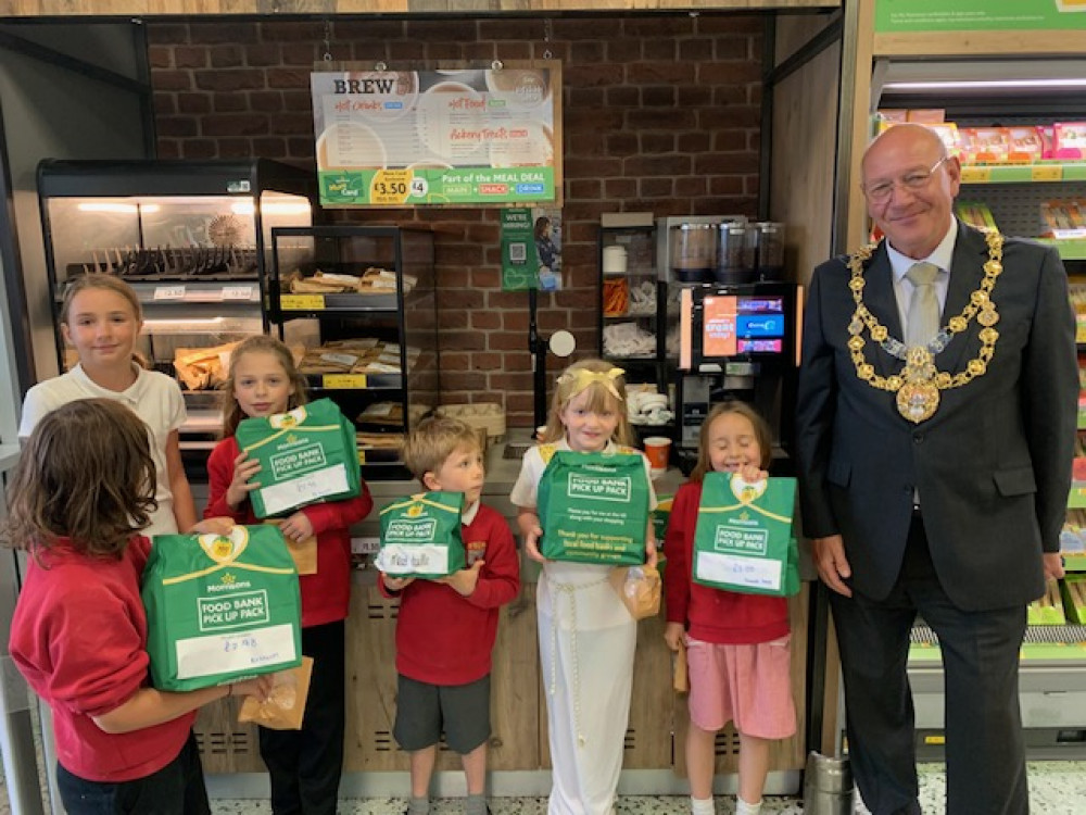 The Mayor of Bridport, Cllr Dave Bolwell, and children from St Mary's Primary School with the foodbank bags at Morrisons in Bridport