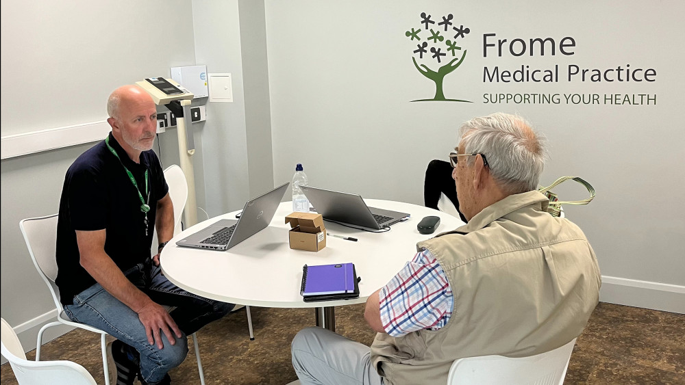 Digital Community Connector Will Palmer, from Frome Medical Practice, with a patient at a Digital Health drop in session