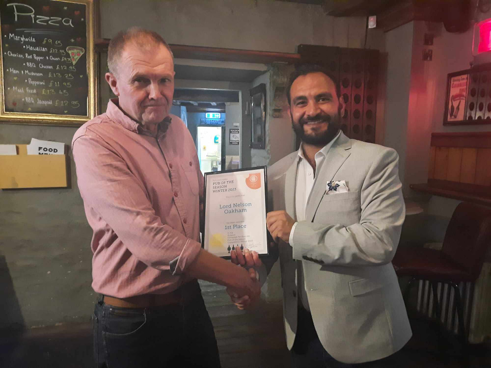 Rich Harris handing Amrit Bola and the team at The Lord Nelson the prestigious Pub of the Season award. Image credit: Nub News. 
