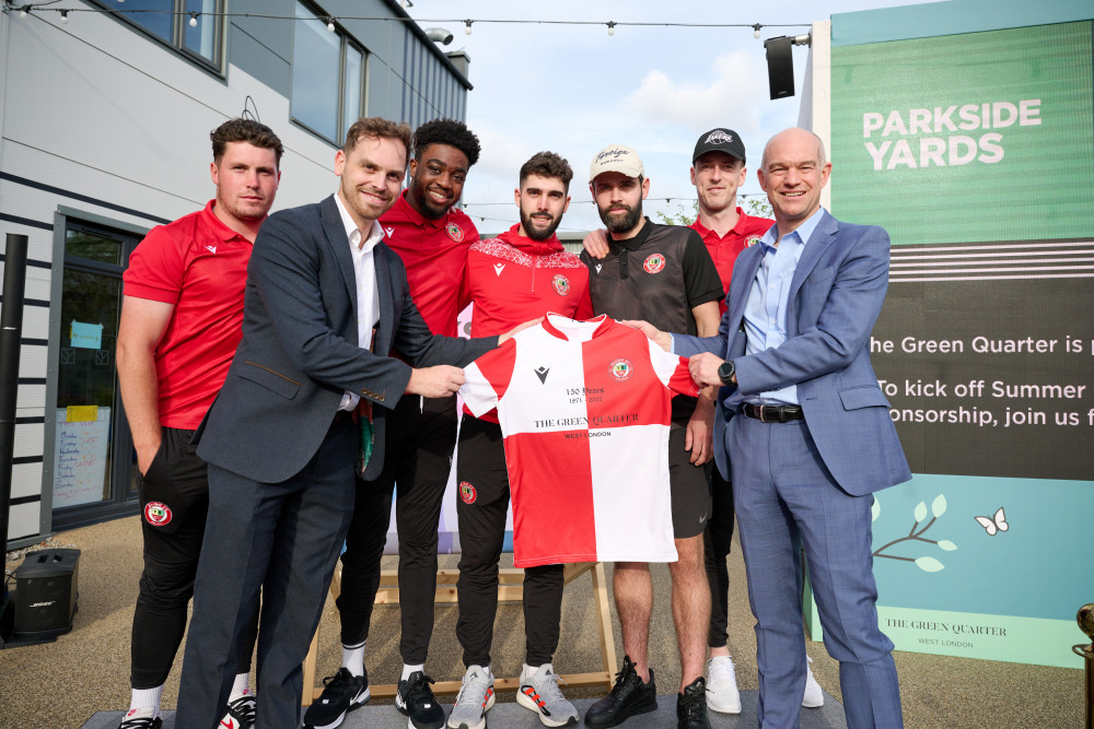 James Purton, Operations Director at St George City, Berkeley, and Marcus Blake, Managing Director of St George City, Berkeley, hold the sponsored shirt in front of members of the team 