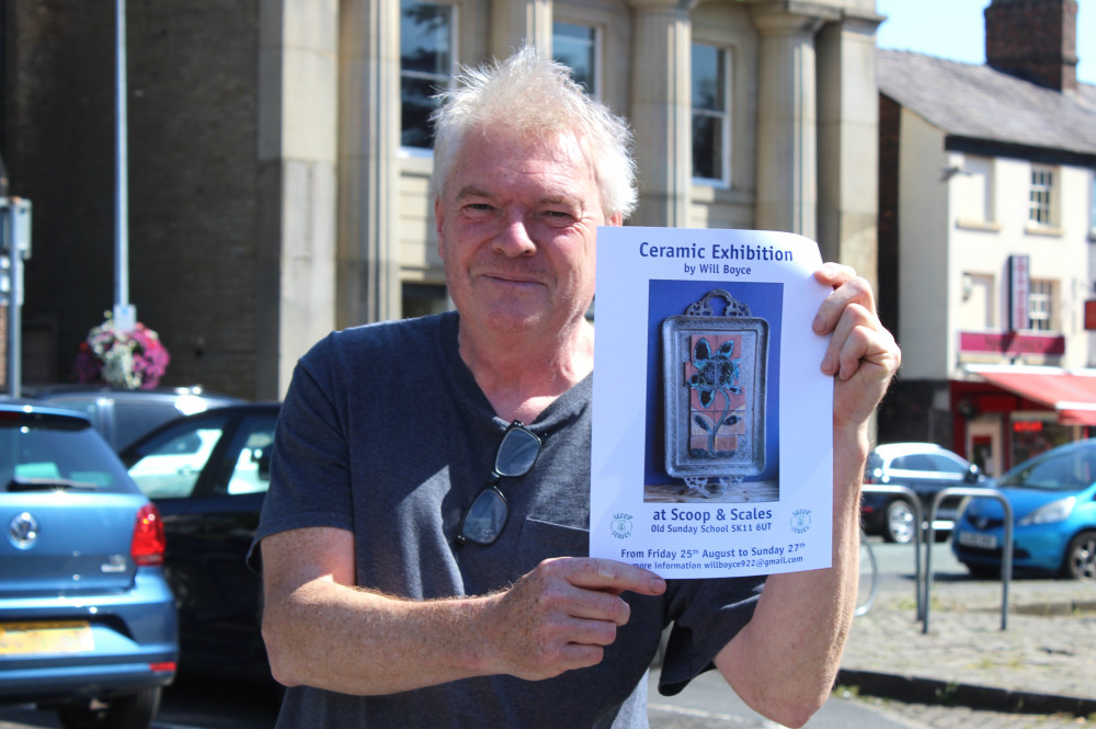 Will pictured with a poster for his exhibit. 