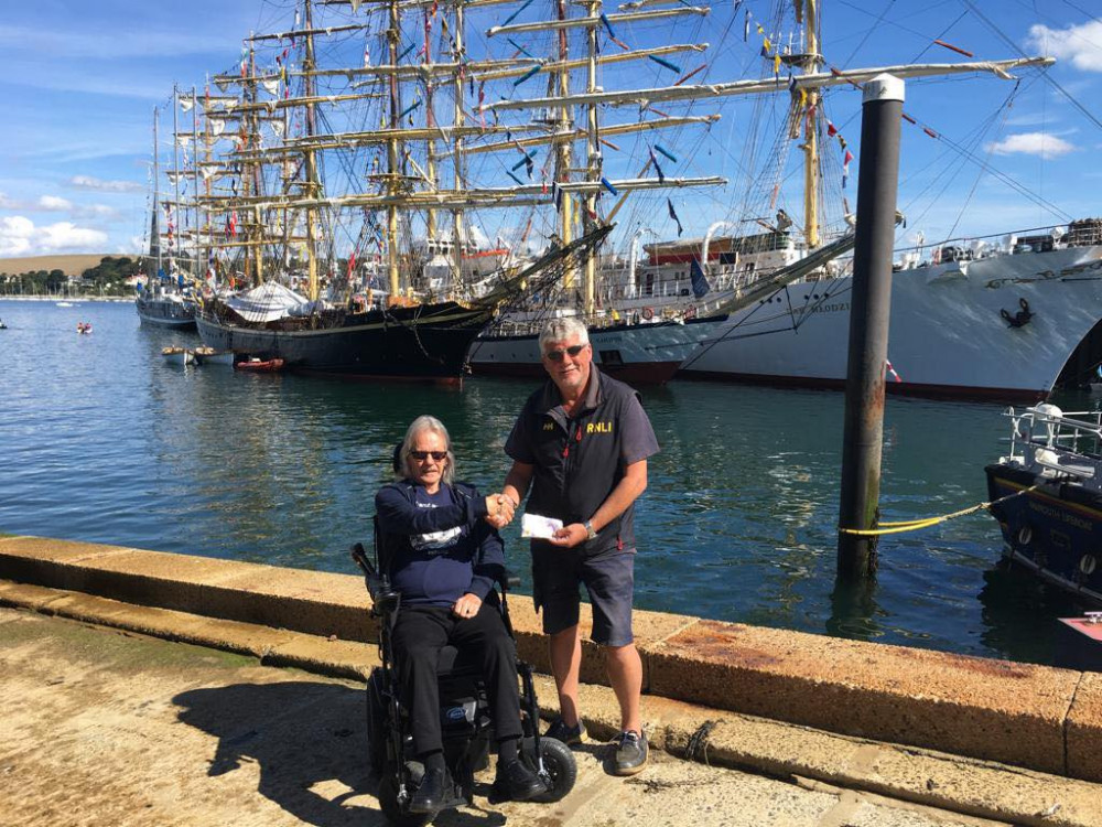 The photo was taken when Eric visited the station during the Tall Ships event and presented the money to Falmouth RNLI Coxswain Jonathon Blakeston. (Image: Falmouth Lifeboat) 